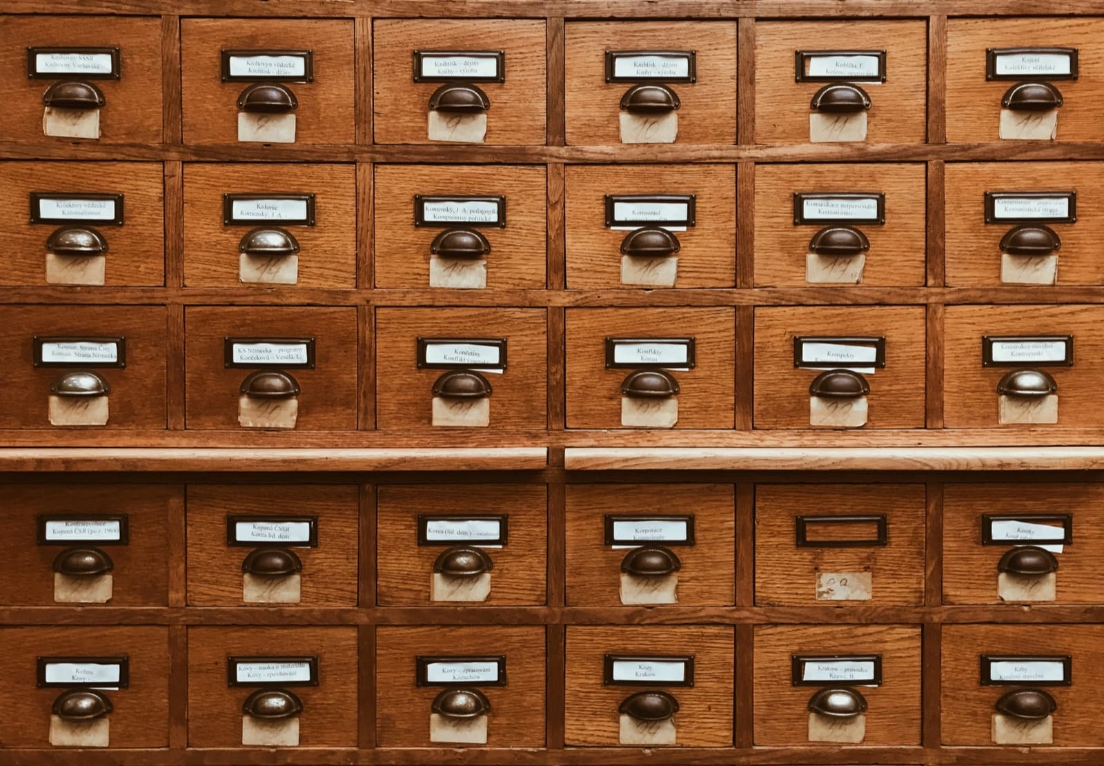Vintage wooden library card catalog with labeled drawers: the validated continence assessment tool a clinician keeps as a reference